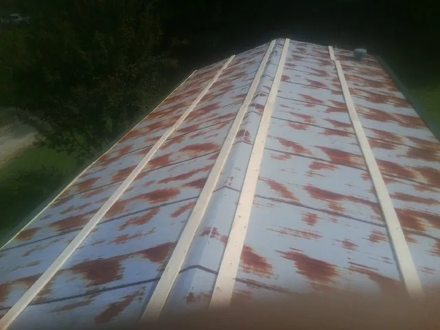 Rusted metal roof panels with new wood purlins before replacement — Storm Damage Roof Repair in Delmont by Roofing Brothers